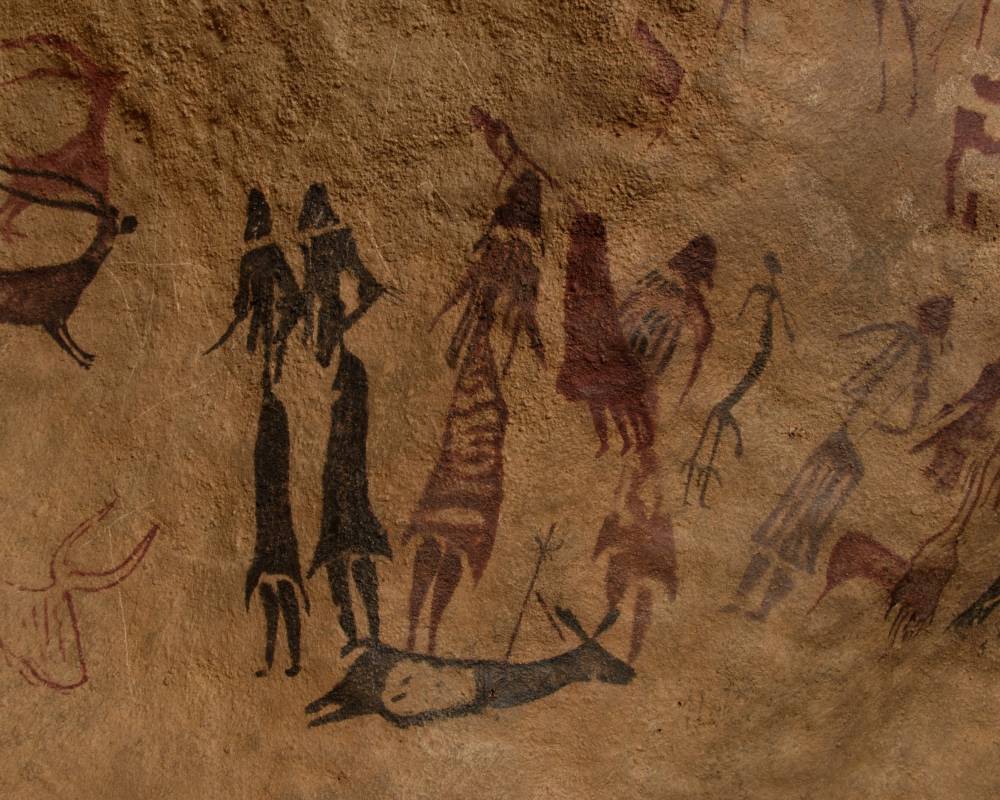 Peintures rupestres de couleur rouge et noire, peintes sur la pierre et représentant des femmes et des animaux.