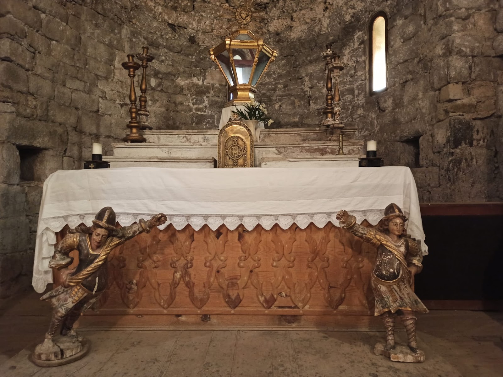 Muntatge de mobiliari religiós a l’interior de l’església de Sant Feliu de Barruera: frontal d’altar del segle XIX, amb predel·la del segle XVI al damunt i talles del segle XX a sobre.
