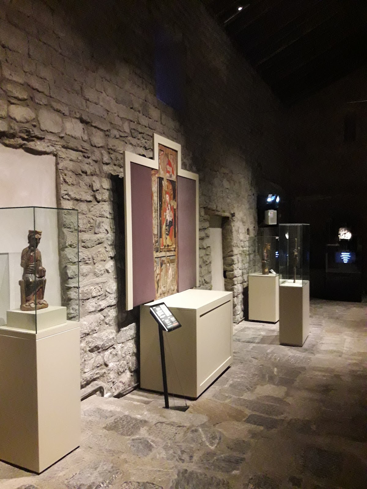 Imatge general de l’interior de la nau sud de l’església de Sant Climent amb les tres talles romàniques dins les urnes de vidre.