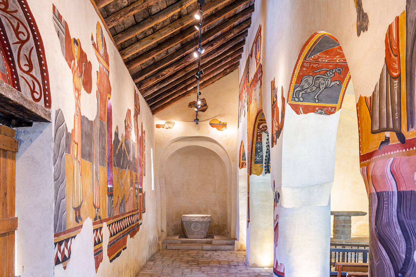 Conjunt de pintures murals de la nau esquerra mirant cap a l’altar de l’interior de l’església de Sant Joan de Boí.