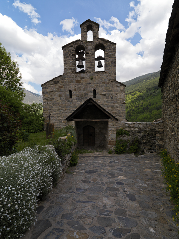 Façana principal de l’església de Santa Maria de Cardet amb el porxo i el campanar d’espadanya.