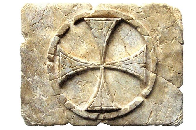 Baix relleu d’una creu patent, símbol dels templers, inscrita en un cercle i esculpida sobre pedra.