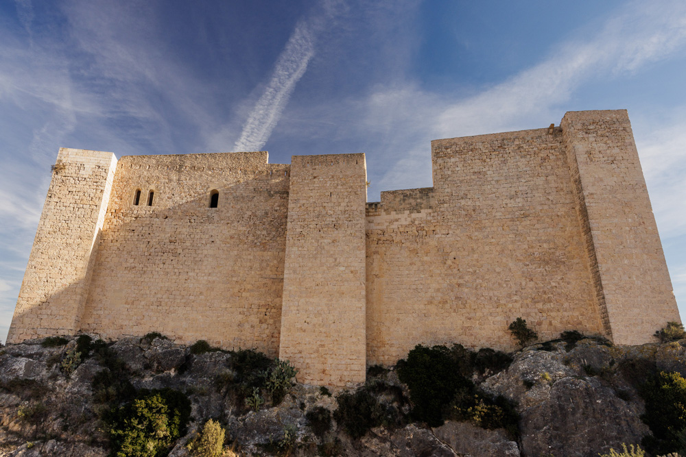 Vista general i contrapicada de la façana oest del castell, construït sobre la roca.
